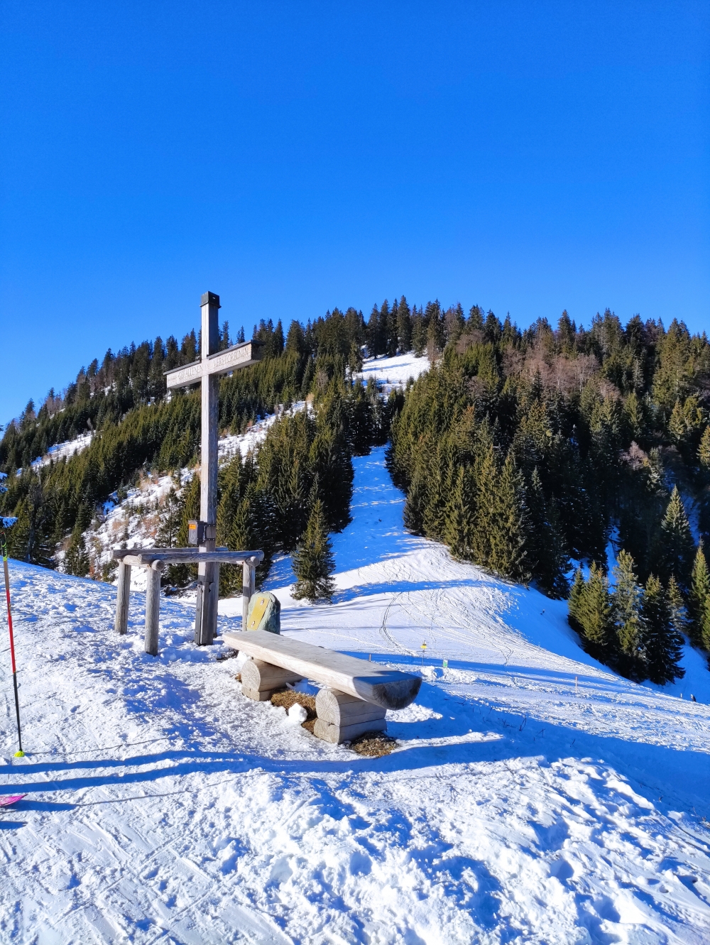 Rodeln Unternberg: Aufstieg über den Unternbergsattel mit Kreuz, im Hintergrund der Eisenberg